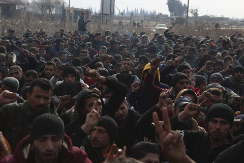 Para anggota pasukan keamanan pemerintah Suriah yang ditahan berkumpul di luar ruangan di fasilitas penahanan sementara di kota Homs, Suriah tengah, Minggu (8/12/2024). Foto: Aaref Watad/AFP