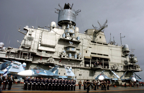 Personel Angkatan Laut berdiri di depan kapal induk Rusia Kuznetsov di kota Tartous, Suriah, di laut Mediterania (8/1/2012). Foto: Sana Sana/REUTERS
