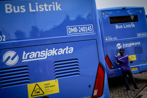 Petugas membersihkan bus listrik Transjakarta berjejer di kawasan Monumen Nasional, Jakarta, Selasa (10/12/2024). Foto: Jamal Ramadhan/kumparan