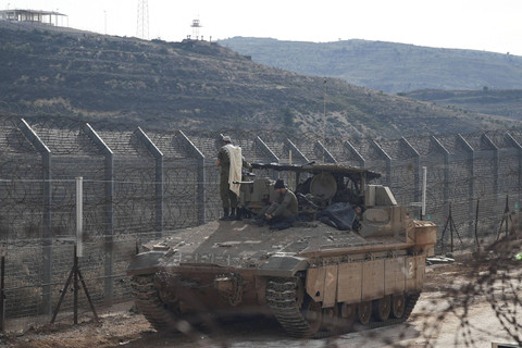 Tentara Israel berada di atas kendaraan pengangkut personel lapis baja (APC) dan Namer sedang shalat di sepanjang sisi Dataran Tinggi Golan di garis gencatan senjata antara Suriah dan Dataran Tinggi Golan yang diduduki Israel, Selasa (10/12/2024). Foto: Miro Maman/REUTERS