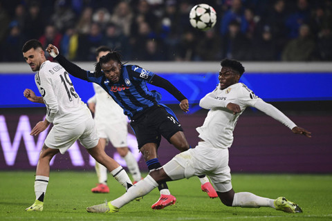 Pemain Atalanta Ademola Lookman menendang bola yang coba dihadang pemain Real Madrid Aurelien Tchouameni dalam pertandingan Liga Champions Eropa di Gewiss Stadium, Bergamo, Italia, Selasa (10/12/2024). Foto: Marco Bertorello/AFP