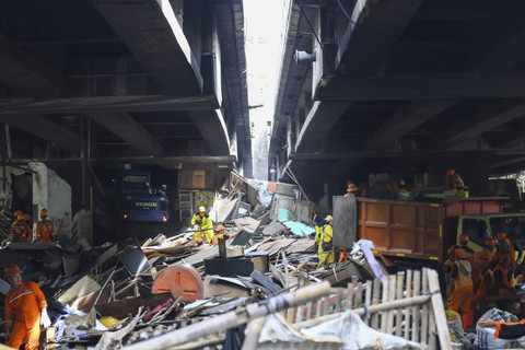 Sejumlah petugas mengevakuasi seorang warga saat membersihkan bekas hunian semi permanen di kolong Tol Angke, Jalembar Baru, Jakarta, Rabu (11/12/2024).  Foto: Sulthony Hasanuddin/ANTARA FOTO 