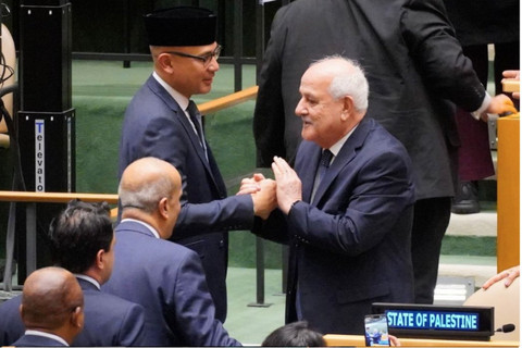 Diplomat Indonesia dan Palestina bersalaman dalam Majelis Umum PBB yang mengadopsi 2 resolusi soal gencatan senjata di Gaza dan operasi UNWR (Rabu, 11/12/2024). Foto: X/@indonesiaunn