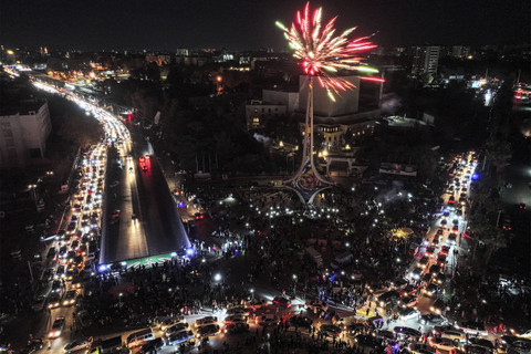 Foto udara ini menunjukkan orang-orang merayakan penggulingan presiden Suriah Bashar al-Assad di dekat patung Pedang Damaskus yang terkenal di Umayyad Square di pusat kota Damaskus, Jumat (13/12/2024).  Foto: Omar Haj Kadour/AFP