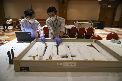 Konservator museum memeriksa benda cagar budaya yang dipulangkan dari Belanda ke Indonesia di Museum Nasional, Jakarta, Senin (16/12/2024). Foto: Iqbal Firdaus/kumparan