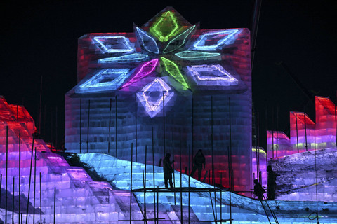 Para pekerja mempersiapkan pahatan es menjelang festival tahunan Harbin Ice and Snow World di Harbin, provinsi Heilongjiang Timur Laut China, Senin (16/12/2024). Foto: Adek Berry/AFP