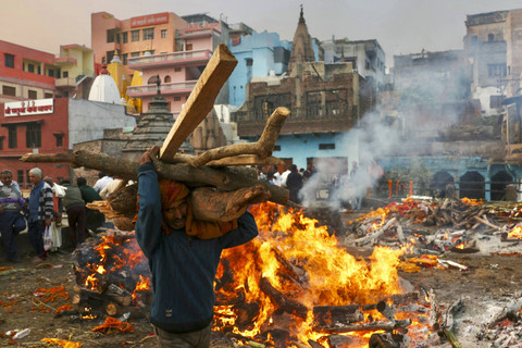 Seorang kremator dari komunitas Dom membawa kayu untuk membakar jenazah di Varanasi, India, Selasa (17/12/2024). Foto: Niharika Kulkarni/Reuters
