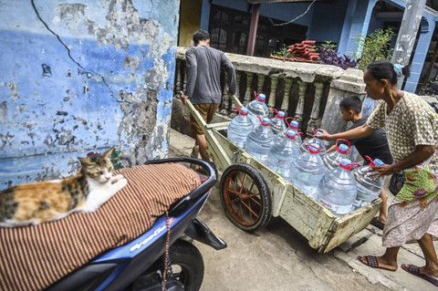 Warga membawa bantuan air bersih dengan gerobak di kawasan Lodan, Pademangan, Jakarta, Rabu (18/12/2024). Foto: Rivan Awal Lingga/ANTARA FOTO