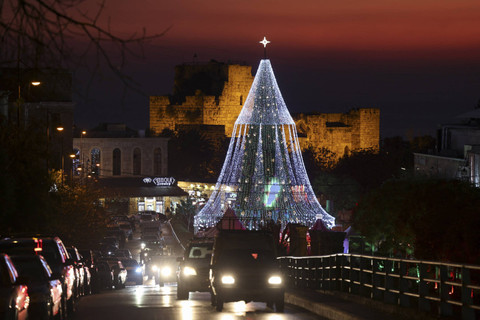 Kendaraan melintas di dekat pohon Natal yang diterangi lampu yang diletakkan di dekat benteng Byblos saat musim liburan, Lebanon, Selasa (17/12/2024). Foto: Mohamed Azakir/REUTERS