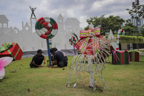 Pekerja menyelesaikan dekorasi nuansa Natal di Taman Lapangan Banteng, Sawah Besar, Jakarta Pusat, Jumat (20/12/2024). Foto: Jamal Ramadhan/kumparan