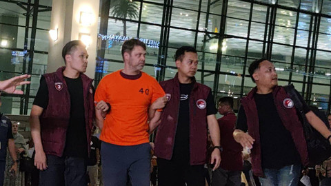 Petugas membawa buronan kasus narkoba asal Ukraina Roman Nazarenco saat tiba di Bandara Soekarno-Hatta, Banten, Minggu (11/12/2024). Foto: Jonathan Devin/kumparan