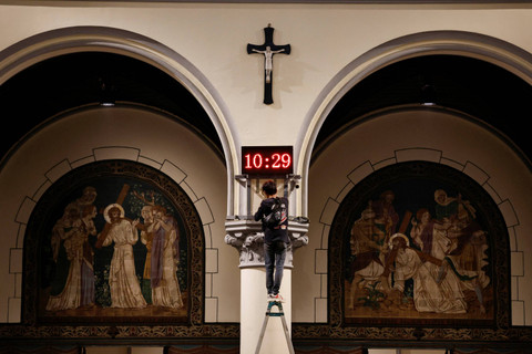 Petugas memasang jam digital untuk mempersiapkan misa Natal 2024 di Gereja Katedral Jakarta, Jakarta, Senin (23/12/2024).  Foto: Ajeng Dinar Ulfiana/REUTERS