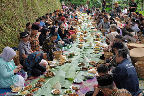 Warga menyantap makanan bersama saat tradisi Nyadran Perdamaian di dusun toleransi Krecek, Getas, Kaloran, Temanggung, Jawa Tengah, Jumat (27/12/2024). Foto: ANTARA FOTO/Anis Efizudin