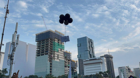 Masa aksi tolak PPN 12 persen di Patung Kuda, Jakarta menerbangkan balon bertuliskan "PPN" pada Jumat (27/12). Foto: Abid Raihan/kumparan