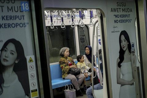 Tiga penumpang berada di dalam rangkaian kereta MRT di Stasiun Dukuh Atas, Jakarta, Sabtu (28/12/2024). Foto: Jamal Ramadhan/kumparan