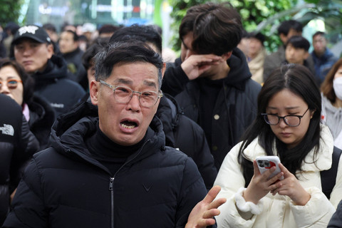 Keluarga penumpang Jeju Air yang mengalami kecelakaan menangis di Bandara Internasional Muan, Provinsi Jeolla, Korea Selatan, Minggu (29/12/2024). Foto: Kim Hong-Ji/REUTERS