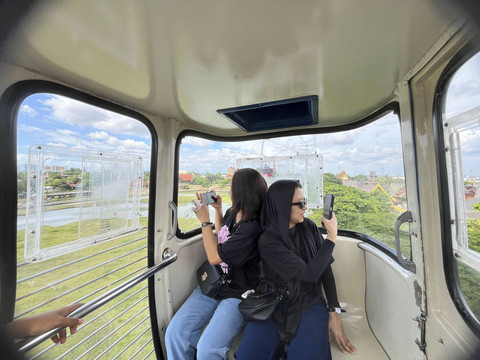 Yestri (29) dan Riva (19) mencoba wahana kereta gantung untuk pertama kalinya di Taman Mini Indonesia Indah, Jakarta Timur, Rabu (1/1/2024). Foto: Alya Zahra/kumparan 