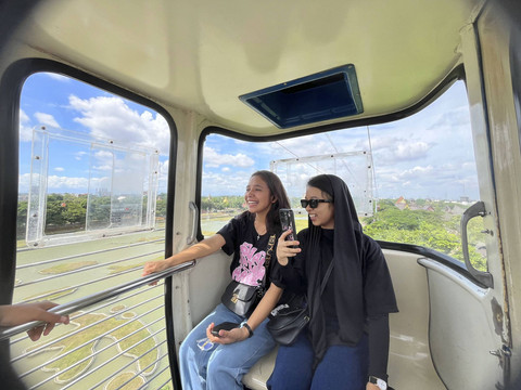 Yestri (29) dan Riva (19) mencoba wahana kereta gantung untuk pertama kalinya di Taman Mini Indonesia Indah, Jakarta Timur, Rabu (1/1/2024). Foto: Alya Zahra/kumparan 