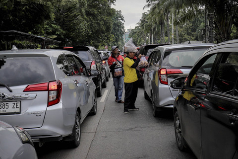 Pedagang menawarkan jualannya pada kendaraan yang terjebak macet di Jalan TB Simatupang arah menuju ke Taman Margasatwa Ragunan, Rabu (1/1/2025). Foto: Jamal Ramadhan/kumparan