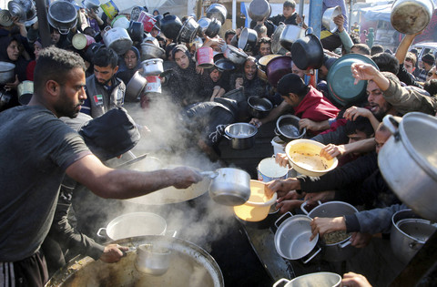 Warga Palestina berkumpul untuk menerima makanan di tengah krisis kelaparan akibat konflik Israel-Hamas, di Khan Younis, Jalur Gaza selatan, Kamis (2/1/2025). Foto: Hatem Khaled/REUTERS