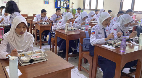 Siswa menyantap makanan saat Menteri Pendidikan Dasar dan Menengah Abdul Mu'ti memantau pemberian makan bergizi gratis di SMP 12 Semarang, Senin (6/1/2025). Foto: Intan Alliva Khansa/kumparan