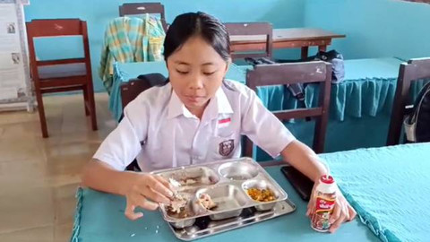 Seorang siswa di Langowan, Minahasa, menyantap menu makan bergizi gratis.