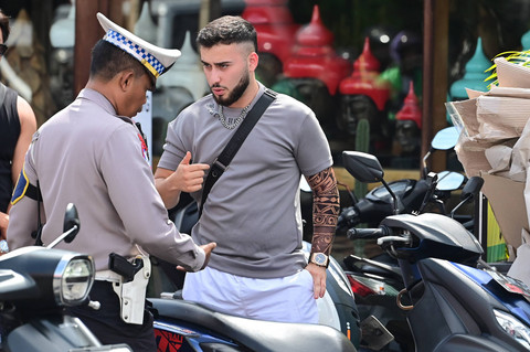 Personel Satlantas Polres Badung menghentikan wisatawan mancanegara untuk ditindak karena melanggar aturan lalu lintas di kawasan Kerobokan, Badung, Bali, Senin (6/1/2025). Foto: ANTARA FOTO/Fikri Yusuf