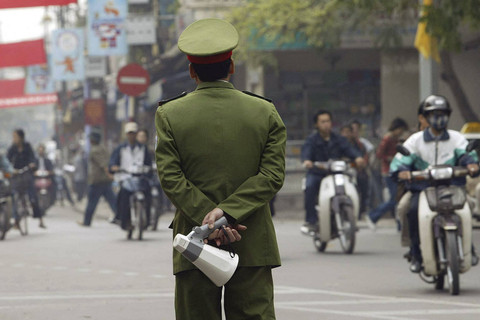 Seorang polisi berjaga di sebuah jalan yang sibuk di pusat kota Hanoi (2/12/2003). Foto: Hoang Dinh Nam/AFP
