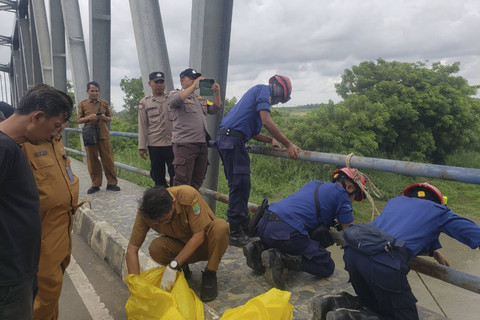 Petugas saat membersihkan sampah medis yang berserakan di bagian bawah jembatan penghubung Karawang-Bekasi, tepat di atas aliran sungai Citarum. Foto: Dok. Istimewa
