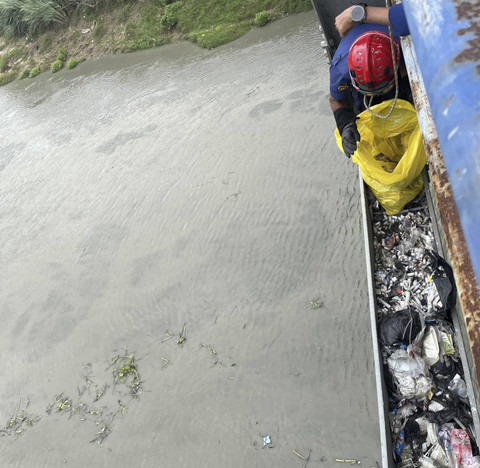 Petugas saat membersihkan sampah medis yang berserakan di bagian bawah jembatan penghubung Karawang-Bekasi, tepat di atas aliran sungai Citarum. Foto: Dok. Istimewa
