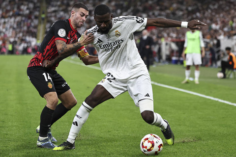 Pemain Real Madrid Antonio Rudiger berebut bola dengan pemain Real Mallorca Daniel Rodriguez pada pertandingan semi final Piala Super Spanyol di King Abdullah Stadium, Jeddah, Arab Saudi, Kamis (10/1/2025). Foto: Fadel Senna/AFP