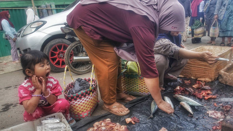 Seorang anak perempuan yang masih mengantuk tengah menemani ibunya berbelnja di pasar tradisionl Desa Palak Tanah, Semende Darat Tengah, Kabupaten Muara Enim, Sumsel, Minggu (12/1) Foto: ary priyanto/urban id
