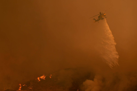 Helikopter pemadam kebakaran berjuang melawan Kebakaran Palisades di Mandeville Canyon, California, Sabtu (11/1/2025). Foto: Jae C. Hong/AP Photo
