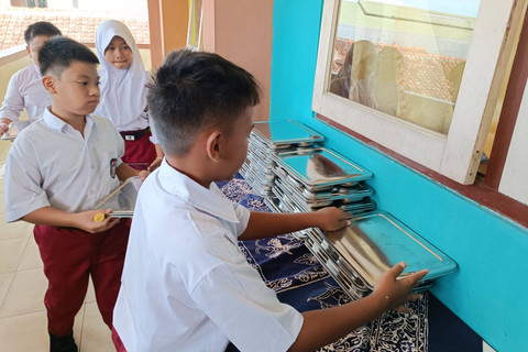 Murid menikmati paket makan program Makan Bergizi Gratis (MBG) di SD Sinduadi Timur, Kapanewon Mlati, Kabupaten Sleman, Senin (13/1/2025). Foto: Arfiansyah Panji Purnandaru/kumparan