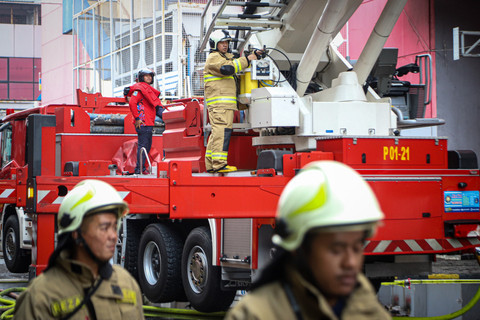 Petugas pemadam kebakaran menggunakan kendaraan High Pressure Pump Unit untuk melakukan pendinginan Glodok Plaza akibat kebakaran, Kamis (16/1/2025). Foto: Iqbal Firdaus/kumparan