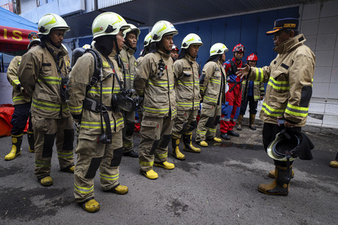 Petugas Damkar berkumpul saat bersiap melakukan pencarian korban kebakaran di Glodok Plaza, Jakarta, Jumat (17/1/2025). Foto: Iqbal Firdaus/kumparan