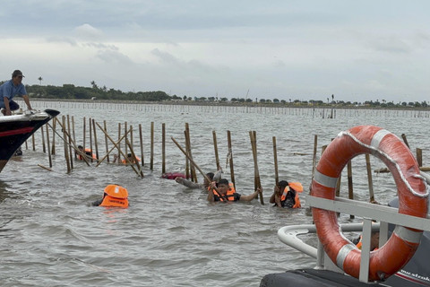 Sejumlah warga dan TNI AL berusaha membongkar pagar laut di perairan Tangerang, Banten, Sabtu (18/1/2025). Foto: Abid Raihan/kumparan