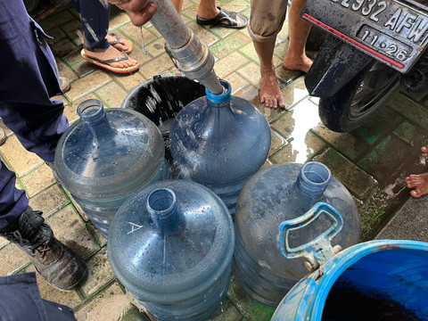 Damkarmat Kota Bandar Lampung menyalurkan air bersih di lokasi warga yang terdampak banjir Jalan RE Marthamartadinata, tepatnya Kampung Pasar Ambon, Pesawahan, Teluk Betung Selatan. | Foto: Sinta Yuliana/Lampung Geh