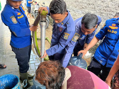 Damkarmat Kota Bandar Lampung menyalurkan air bersih di lokasi warga yang terdampak banjir Jalan RE Marthamartadinata, tepatnya Kampung Pasar Ambon, Pesawahan, Teluk Betung Selatan. | Foto: Sinta Yuliana/Lampung Geh