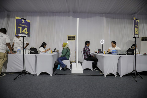 Masyarakat dilayani petugas saat membuat paspor di kawasan Gelora Bung Karno, Jakarta, Minggu (19/1/2025). Foto: Jamal Ramadhan/kumparan