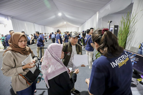 Masyarakat menyiapkan dokumen saat membuat paspor di kawasan Gelora Bung Karno, Jakarta, Minggu (19/1/2025). Foto: Jamal Ramadhan/kumparan