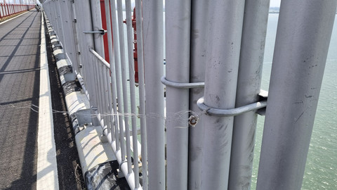 Senar putih terikat di pagar pengaman Jembatan Surabaya-Madura (Suramadu), Minggu (19/1/2025). Foto: Farusma Okta Verdian/kumparan