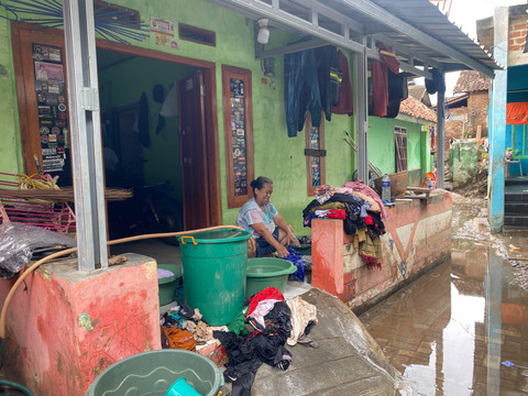 Warga mencuci pakaian kotor akibat terendam banjir. | Foto: Sinta Yuliana/Lampung Geh