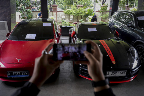 Jurnalis mengambil gambar barang bukti berupa mobil mewah terkait kasus penipuan investasi bodong robot trading NET89 di Bareskrim Polri, Jakarta Selatan, Rabu (22/1/2025). Foto: Jamal Ramadhan/kumparan