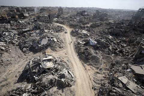 Sejumlah warga berjalan di dekat bangunan yang hancur akibat gencatan senjata Hamas-Israel di Jabalia, Jalur Gaza, Selasa (21/1/2025). Foto: Dawoud Abu Alkas/REUTERS