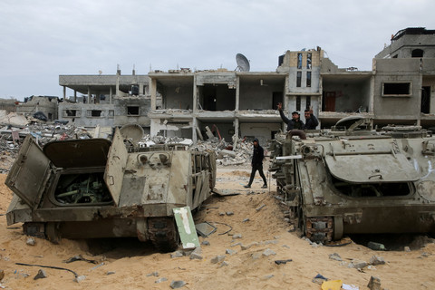Warga Palestina melihat kendaraan militer Israel yang rusak menyusul gencatan senjata antara Israel dan Hamas di Rafah, Jalur Gaza selatan, Rabu (22/1/2025). Foto: Hatem Khaled/REUTERS