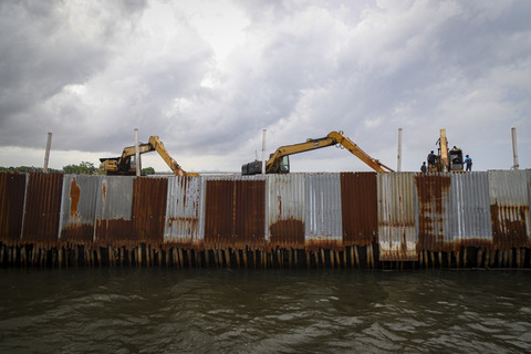 Penampakan alat berat dibalik sebuah pagar laut. Foto: Iqbal Firdaus/kumparan