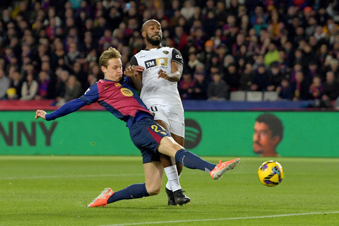 Pemain FC Barcelona Frenkie De Jong mencetak gol ke gawang Valencia pada pertandingan Liga Spanyol di Estadi Olimpic Lluis Companys, Barcelona, Spanyol, Minggu (26/1/2025). Foto: Manaure Quintero / AFP
