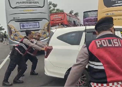Anggota kepolisian Polres Kuningan saat mendorong kendaraan wisatawan yang tidak kuat menanjak, Senin (27/1/2025). Dok: Ist