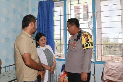 Kapolres Nias Selatan AKBP Ferry Mulyana melihat kondisi anak berusia 10 tahun yang diduga dianiaya keluarganya hingga kakinya bengkok. Foto: Polres Nias Selatan